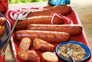 Red tray of assorted cooked sausages