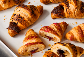 Parchment-lined pan of Raspberry croissants and Cocoa-Hazelnut croissants