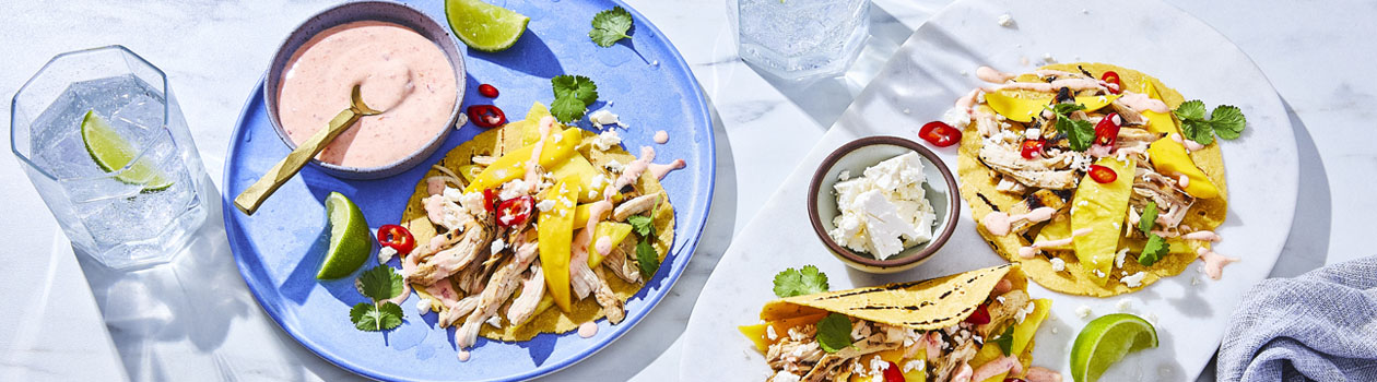 three Tropical Sweet and Spicy Chicken Tacos with mango, cheese, chilis, cilantro and creamy sauce